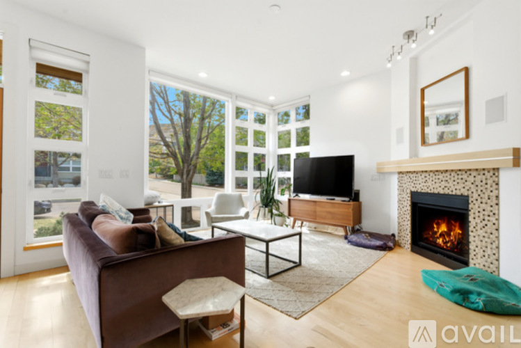 A modern living room with a fireplace and a flat screen TV.
