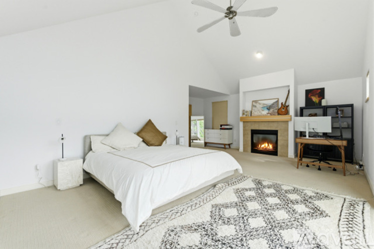 A bedroom with a large bed and a fireplace.
