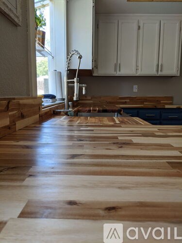 A kitchen with wooden floors and white cabinets.