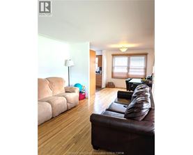 A living room with a brown couch and a lamp.