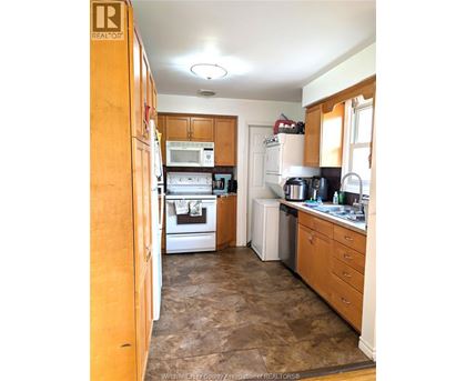 A kitchen with wooden cabinets and appliances.