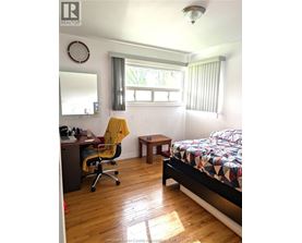 A bedroom with a bed, desk, and chair.