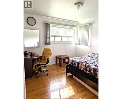 A bedroom with a bed, desk, and chair.