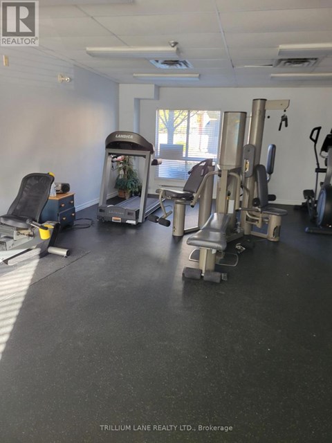 A gym room with a treadmill, weights and exercise equipment.