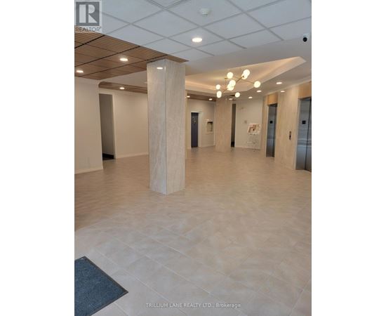 A spacious office hallway with a wooden floor and white walls.