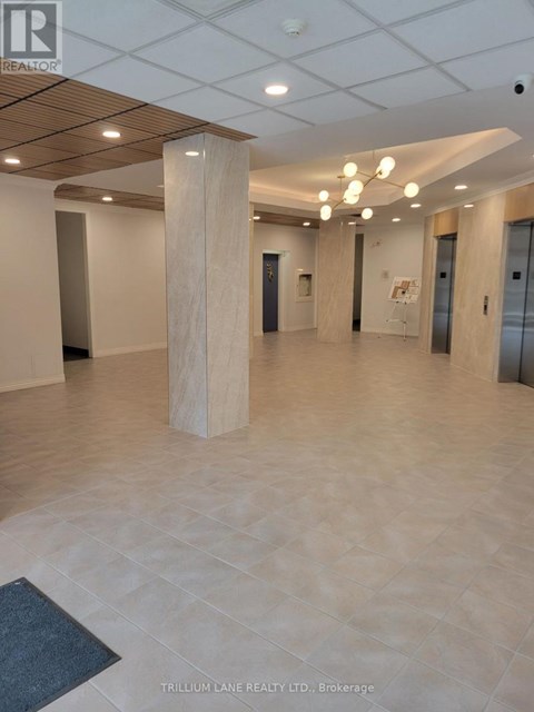 A spacious office hallway with a wooden floor and white walls.