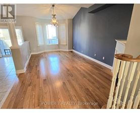 A room with wooden flooring and a chandelier.