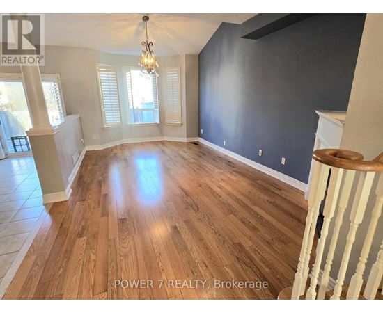 A room with wooden flooring and a chandelier.