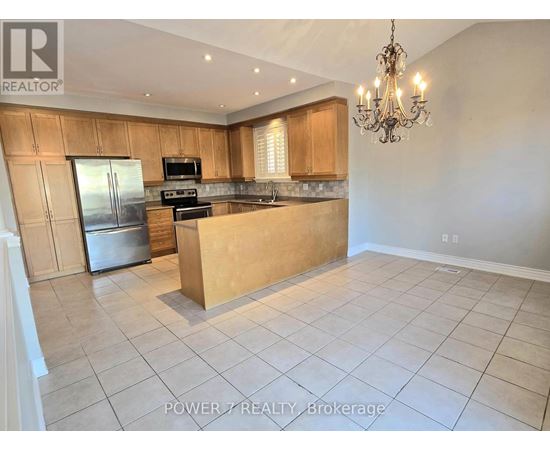A kitchen with wooden cabinets and a refrigerator.
