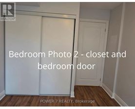 A bedroom photo showing a closet and a bedroom door.
