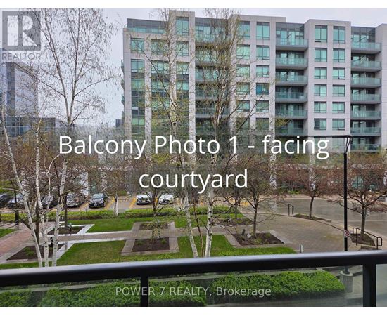 A view of a courtyard from a balcony with a building in the background.