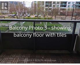 A balcony with tiled flooring and a view of a parking lot and trees.