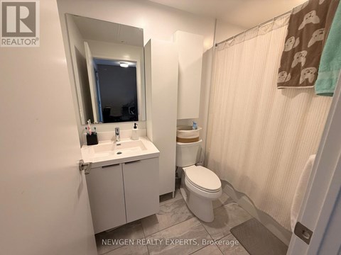A bathroom with a toilet, sink, and mirror.