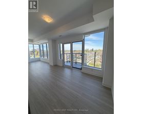 A spacious room with a view of the outside through large windows.