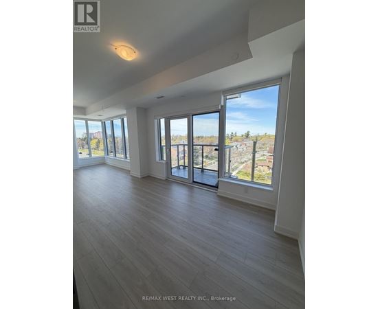 A spacious room with a view of the outside through large windows.