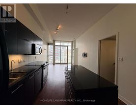 A kitchen with black cabinets and a black countertop.