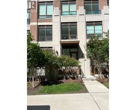 A building with a brown door and windows with trees in front.