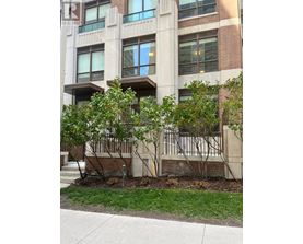 A building with a balcony and trees in front of it.