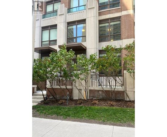 A building with a balcony and trees in front of it.