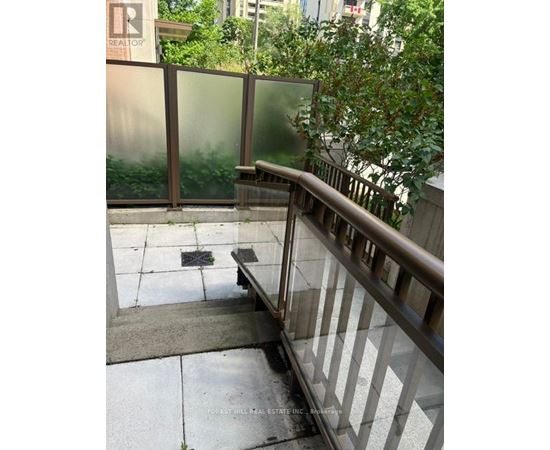 A glass railing with a metal handrail and a concrete floor.