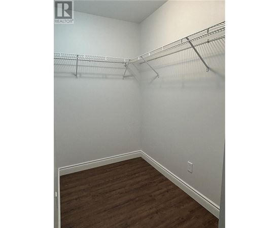 Empty room with a wood floor and a metal rack on the wall.