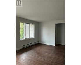 A room with a window and wooden floors.