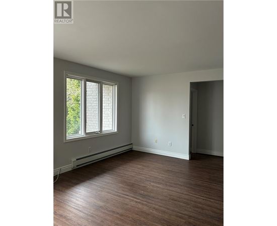 A room with a window and wooden floors.
