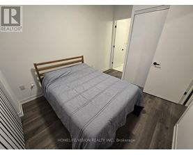 A bedroom with a bed, wooden headboard, and striped carpet.