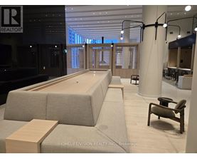 A modern office space with a long couch and a wooden table.