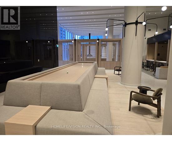 A modern office space with a long couch and a wooden table.