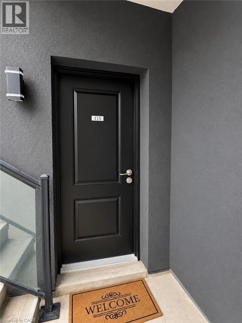 A black door with a glass window on the left and a welcome mat on the right.