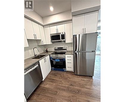 A kitchen with white cabinets and a stainless steel refrigerator.