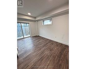 A room with wooden flooring and a window.