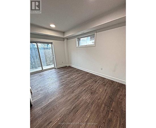A room with wooden flooring and a window.