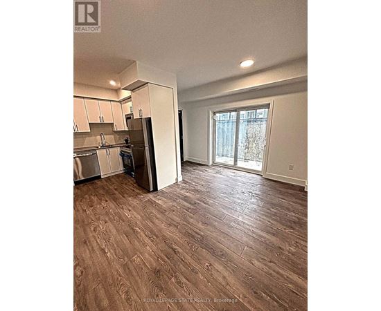 A kitchen with white cabinets and a refrigerator.