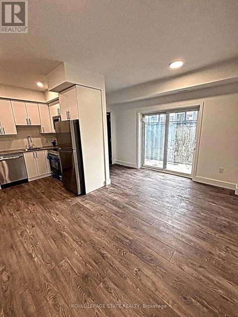 A kitchen with white cabinets and a refrigerator.
