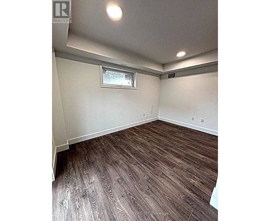 A room with wood flooring and a window.