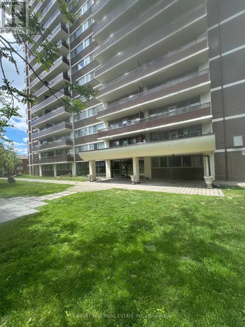 A large apartment building with a grassy area in front.