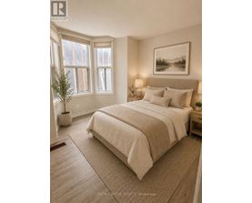 A bedroom with a large bed and a framed picture on the wall.