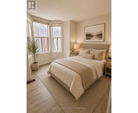 A bedroom with a large bed and a framed picture on the wall.