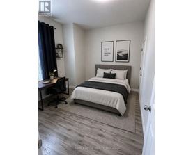 A bedroom with a bed, desk, and chair.