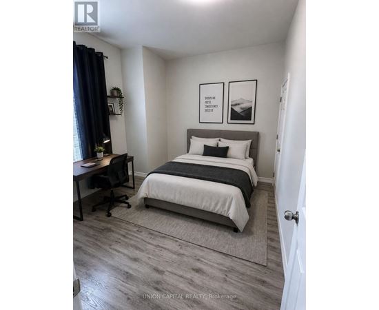 A bedroom with a bed, desk, and chair.
