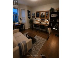 A living room with a couch, desk, and bookshelf.