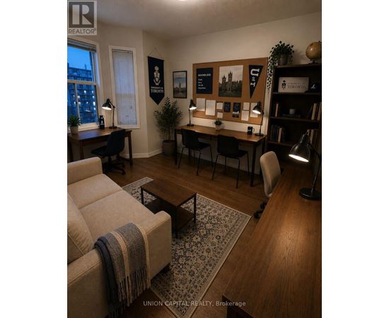 A living room with a couch, desk, and bookshelf.