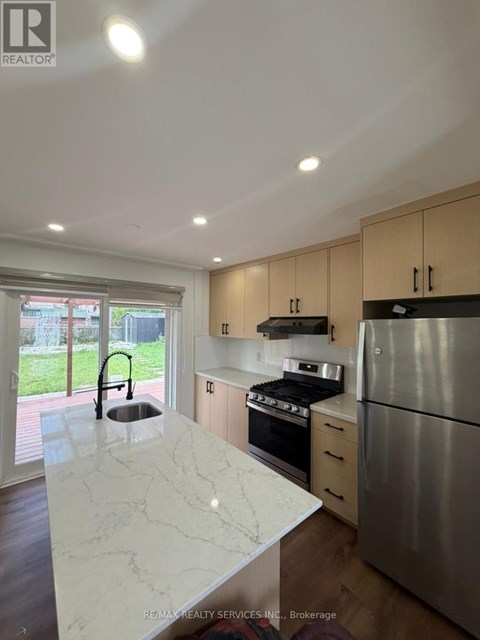 A kitchen with a marble counter top and stainless steel appliances.