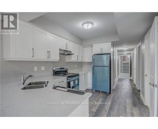 A kitchen with white cabinets and a blue refrigerator.