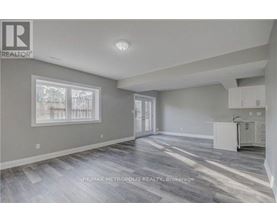 A spacious room with a grey floor and white walls.