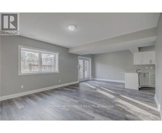 A spacious room with a grey floor and white walls.