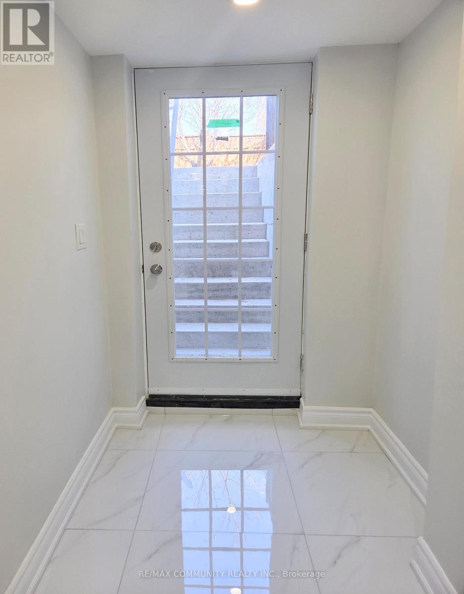 A white door with a glass window is in a white hallway.
