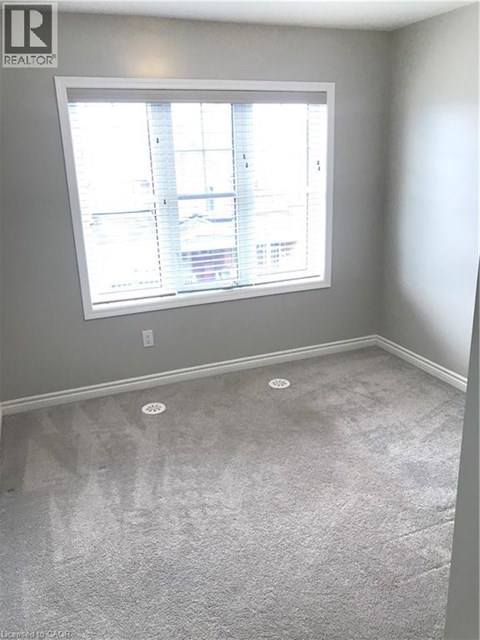 A room with a window and a carpet on the floor.